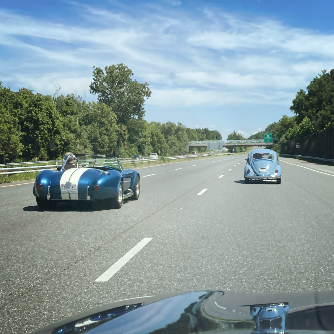 Blue Shelby Cobra 427 passing blue VW Beetle